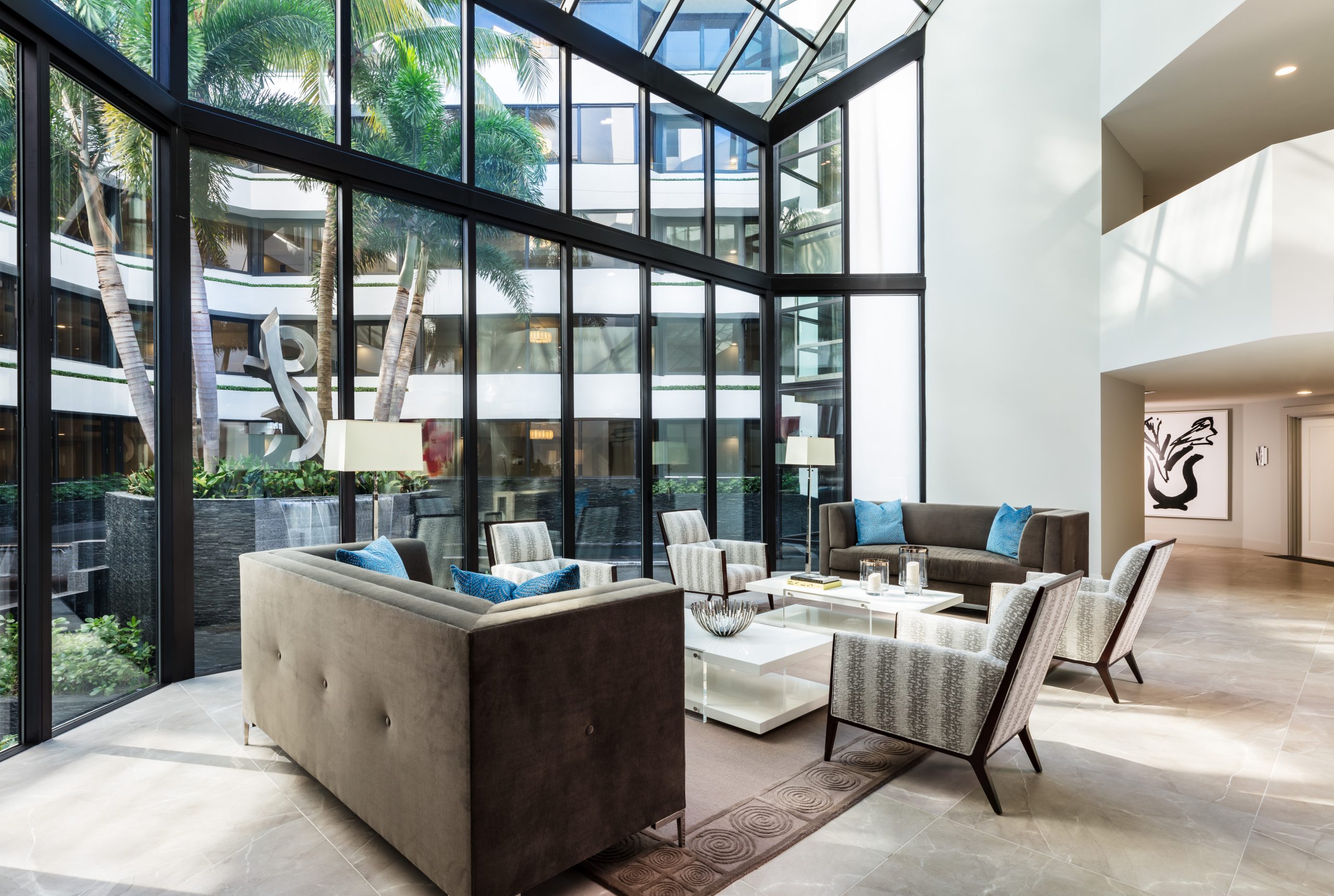 Palm Beach commercial interior designer interior with glass walls, natural light, and modern seating arrangement.